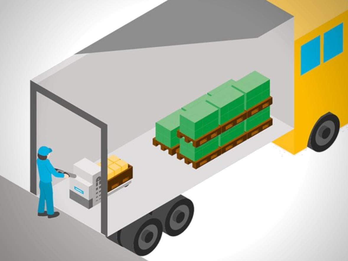 Transpaleta accediendo a un camión de envío en un muelle de carga en almacén